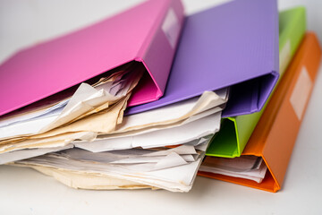 File Folder Binder stack of multi color on table in office.