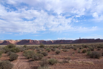 Large sandstone cliffs and colorful bright red wide plateaus make up the western Utah landscape; Valley of the Gods