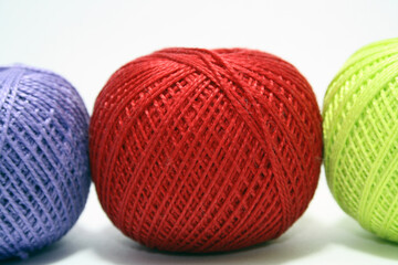 Balls of colored yarn on white background.