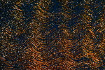 Gold glitter on dark blue bokeh abstract light defocused background.