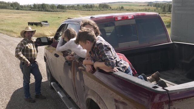 Multigenerational Family At Pickup Truck On Sunny Rural Farm