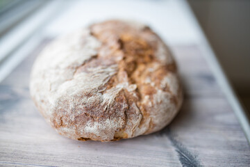Sourdough bread on a white kitchen counter next to a window