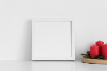 White square frame mockup with candles. Christmas decoration