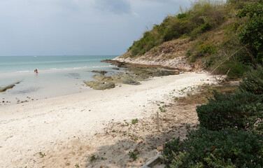 People sunbathe and swim.People walk on the beach after low tide