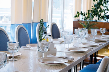 blurred background  elegant table setting with white plate and crystal glass