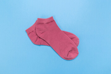 pink new socks stacked on a blue background. top view.