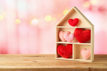 Valentine's Day concept with house toy and heart shape over pink bokeh background