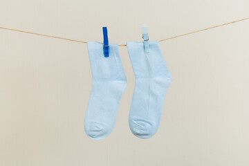 socks, dry after washing, hanging on a clothesline with clothespins on a light background