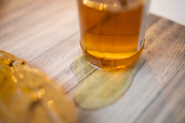 Honey jar and a slice of bread with peanut butter on wooden table