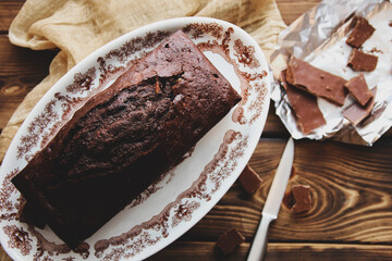 Wet chocolate cake with chocolate icing. Chocolate fudge. Homemade baking. Chocolate cake on wooden background