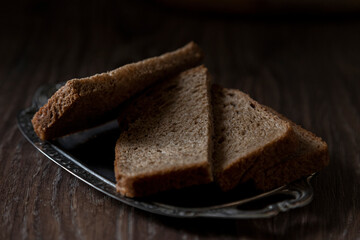 Sliced rye bread on vintage  plate. On a wooden table.