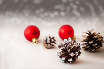 Concept christmas greeting card with the red balls and a pine cone