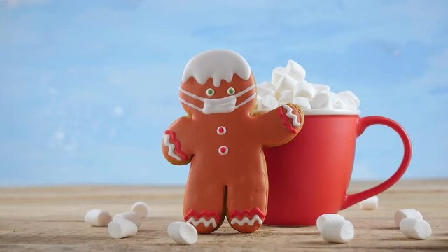 Cute Gingerbread Man with Red Mug of Hot Chocolate in Winter Snow