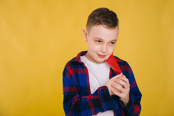 A nine-year-old boy with a mouth taped with red tape. The child is not allowed to speak.