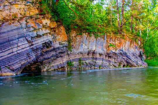 Curved arc rock on the river. River Zilim, South Ural, Russia.