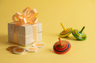 Image of jewish holiday Hanukkah with gift box, wooden dreidels (spinning top),chocolate coins on a...