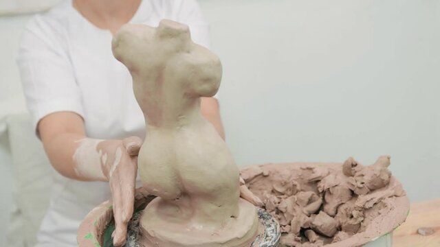 Woman working with clay with her hands. Pottery workshop. master class and training.