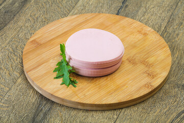 Sliced sausage over the wooden board