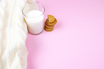 glass of milk with biscuits and wool sweater
