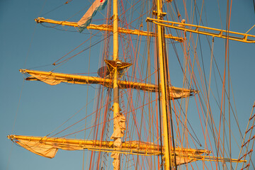 Big historic sailing ship in the port. Yachts and boats at sea against the backdrop of the setting...