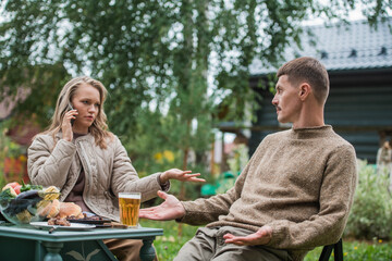 A woman doesn't pay attention to a man at a family picnic. The husband expresses his dissatisfaction with his wife. The problem of the 21st century, the lack of live communication