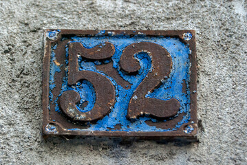 Old retro weathered cast iron plate with number 52 closeup