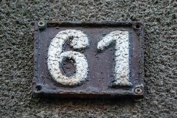 Old retro weathered cast iron plate with number 61 closeup