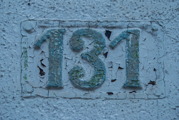 Old retro weathered cast iron plate with number 131 closeup