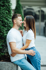 Fototapeta premium Fashion outdoor romantic portrait of beautiful young couple in love and hugs on the street.