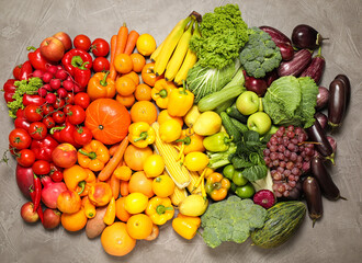 Assortment of organic fresh fruits and vegetables on grey background, flat lay