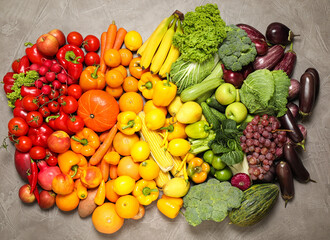 Obraz na płótnie Canvas Assortment of organic fresh fruits and vegetables on grey background, flat lay