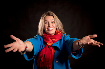 Cheerful 40 years old woman in blue coat and red kerchief welcome gesture
