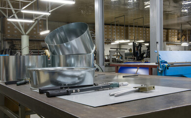 Sheet metal products on the table for work. Fragment of a sheet metal products factory.