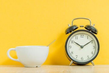 white tea mug and old alarm clock