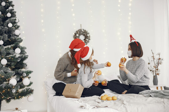 People reparing for Christmas. Two mothers playing with their children. Coronavirus thime. Isolation.