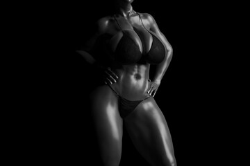 Sexy young woman with big boobs in a black bikini in soft light black and white
