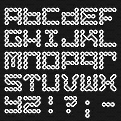Font of twisted strips. Alphabet of white relief letters on a black patterned background.