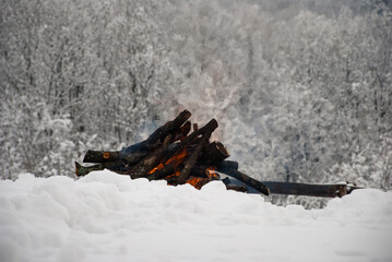 Camp fire in winter time, surrounded by snow