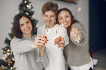 People reparing for Christmas. Mother standing with her son. Family is resting in a festive room. People with champagne and sparklers.