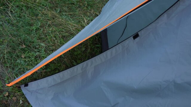 Closeup view 4k video of man hands opening zipper of camping tent 