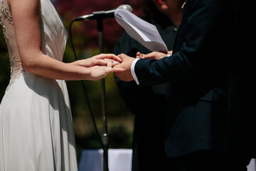 bride holding groom's hand during wedding ceremony