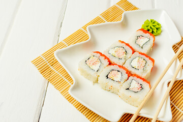 Funny edible Christmas tree made from sushi, creative idea for japanese restaurant on white background. New Year food background