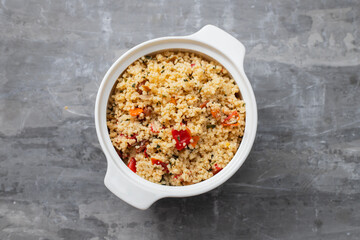 tabbouleh on small white bowl on ceramic background
