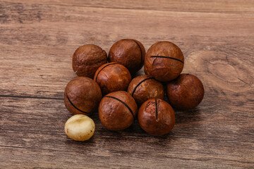 Brown macadamia nut heap over background