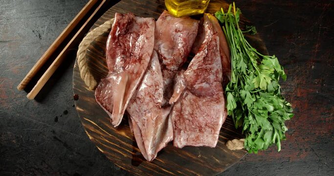 The wooden tray with raw squid rotates slowly. 