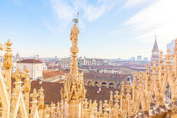 Roof of Milan Cathedral Duomo di Milano with Gothic spires and white marble statues. Top tourist...