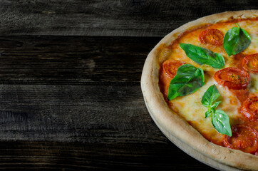Top view to Italian homemade pizza Margarita with tomato, mozzarella and basil on a wooden board