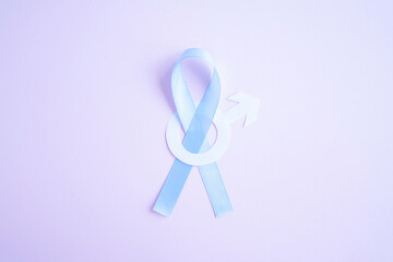 Obraz premium Prostate cancer awareness blue ribbon with white paper male sign mars arrow on pink background. Men healthcare concept, men carcinoma symbol.