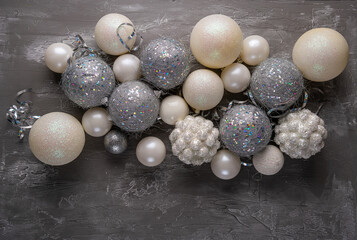 Festive mood, preparation for the holiday. New Year's festive decor in silvery colors - toys, star, round balls, place for an inscription. View from above