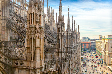 Roof of Milan Cathedral Duomo di Milano with Gothic spires and white marble statues. Top tourist attraction on piazza in Milan, Lombardia, Italy. Wide angle view of old Gothic architecture and art - obrazy, fototapety, plakaty